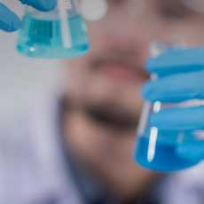 stock photo of a scientist looking at vials